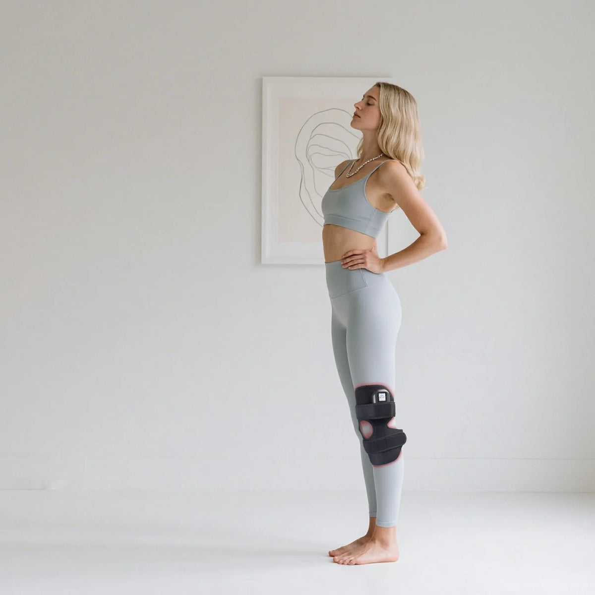 Person using the TLB60-C4 red light therapy knee wrap
